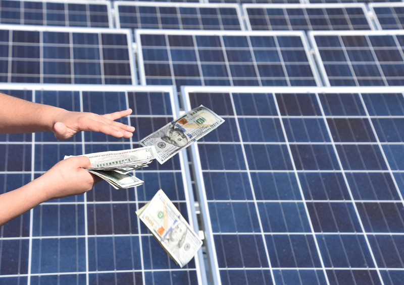 Hundred-dollar bills raining down in front of solar panel