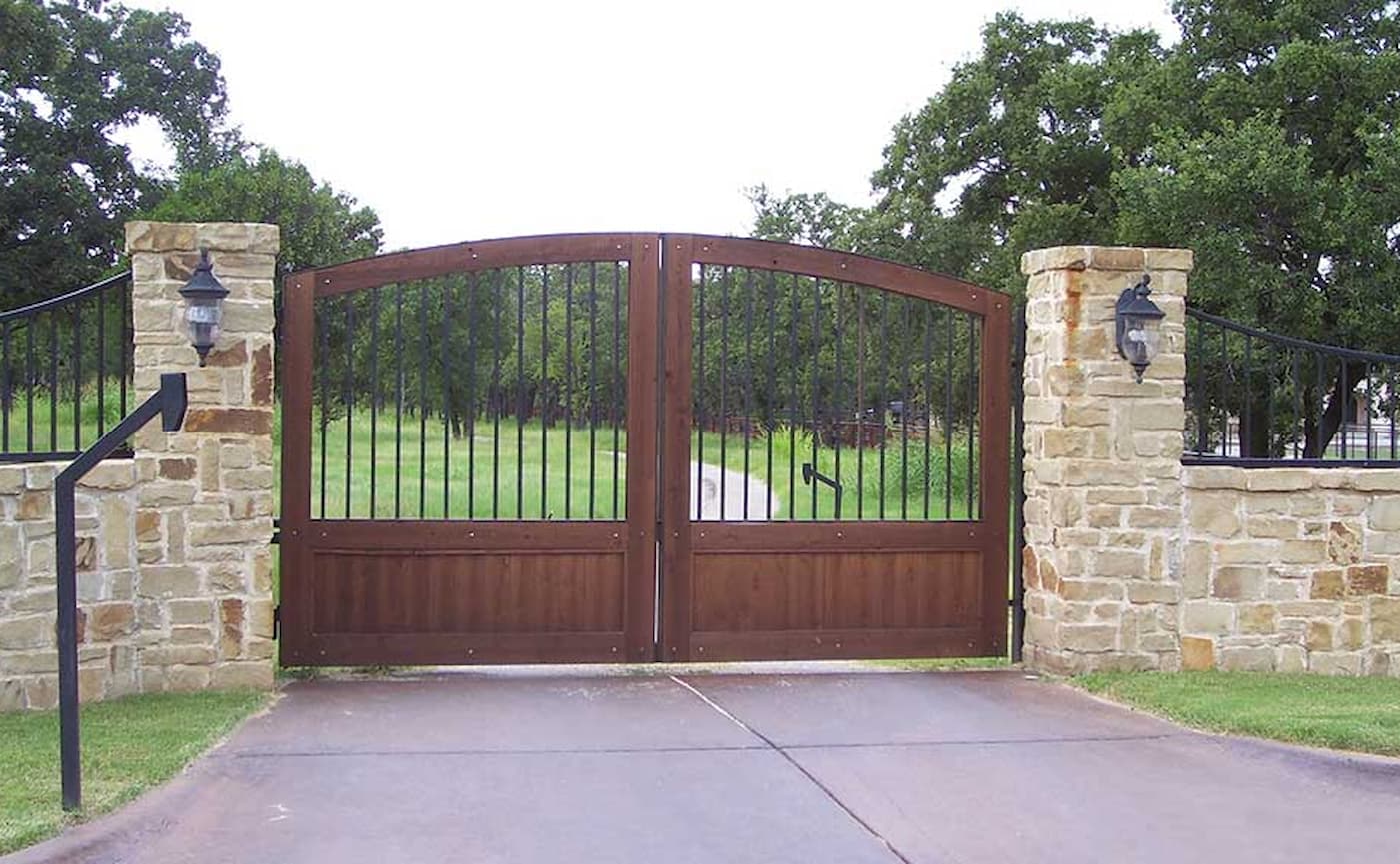 Closed wood and metal gate across a driveway